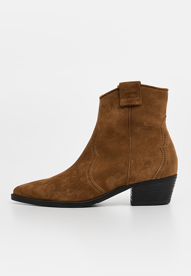 Braune Wildleder-Ankle-Boots mit spitzem Zehenbereich, gewelltem Design und kleinem Blockabsatz. Mit einem Stoffzugschlaufen am Rücken ausgestattet.