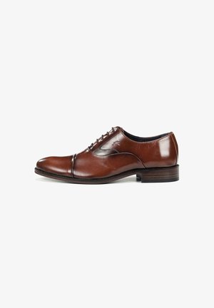Zapato Oxford de cuero marrón con punta redonda, cierre de cordones con cinco ojales, detalles cosidos y tacón de madera. Textura suave, diseño clásico.
