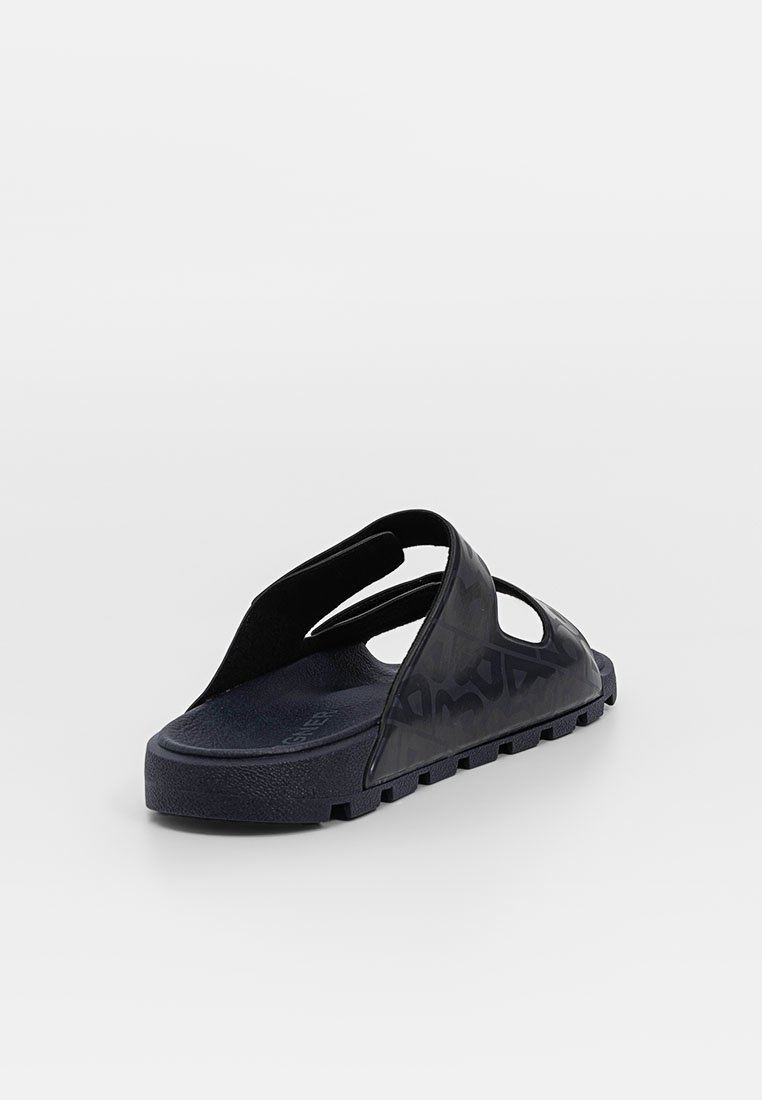 Schwarze Slide-Sandale mit einer strukturierten Sohle. Sie hat eine offene Zehenpartie und eine offene Ferse, mit Ausschnitten zur Belüftung. Hergestellt aus einem strapazierfähigen Material.