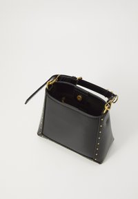 Sac à main en cuir noir avec quincaillerie dorée, accents cloutés sur les côtés, forme rectangulaire et une petite poignée. Design à ouverture supérieure.