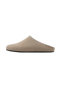 Scarpa slip-on beige in suede con design ergonomico, punta arrotondata, texture morbida e suola in gomma nera. Forma minimalista, senza hardware visibile.
