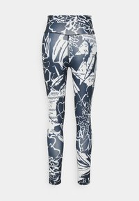 Legginsy z wysokim stanem w granatowo-białym kwiatowym wzorze, charakteryzujące się gładką teksturą i dopasowaną sylwetką.