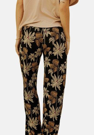 Pantalons noirs avec un motif floral coloré comprenant de grandes feuilles ivoire et de petits accents rouges. Le tissu semble doux avec une coupe décontractée.