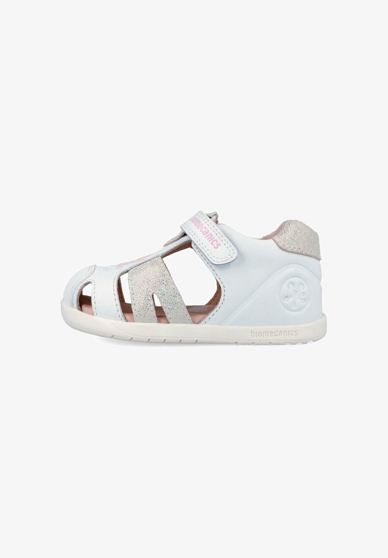 Sandalia blanca y plateada para niño pequeño con punta cerrada, correa de Velcro, detalles con purpurina y suela acolchada, diseñada para comodidad y soporte.