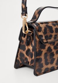 Donet med leopardmønster med blank finish; har en strukturert design, gull-hardwear, og en avtakbar stropp. Teksturet dyremønster.
