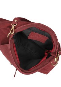 Bordeaux suede tas met een ritssluiting aan de bovenkant en gouden hardware. Interieur is van zwart stof met een ritsvak en een plat label. Rond gevormd.