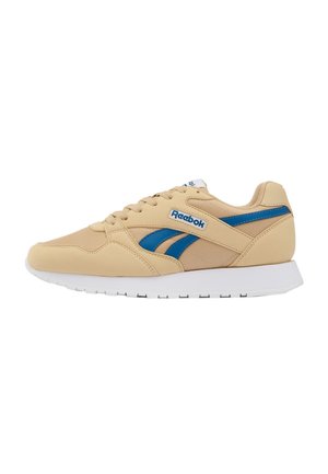 Beżowy sneaker Reebok z niebieskim logo i paskami, biała podeszwa, wiązany, przedstawiony z boku na białym tle.