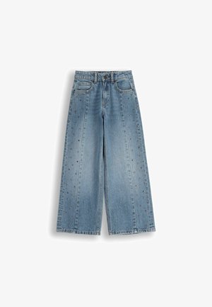 Jasnoniebieskie dżinsowe spodnie w stylu wide-leg, z wysokim stanem, kieszeniami z przodu i metalowymi ćwiekami wzdłuż szwów bocznych.