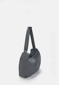 Grå nylon skuldertaske med et blødt, slapt design, som har en enkelt justerbar rem og en sidelomme. Glat tekstur, minimalistisk udseende.