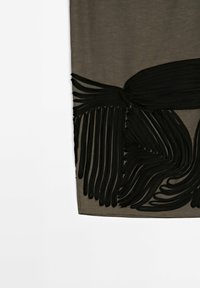 Tissu marron transparent avec appliqué de franges noires abstraites en lignes courbes et droites fluides.