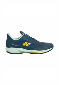 Scarpe atletiche blu con una tomaia testurizzata, accenti blu chiaro e logo giallo. Presentano un design snello e una suola imbottita per il supporto.