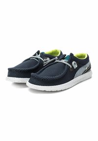 Zapatos de slip-on de malla en color navy con una suela blanca moteada y acentos grises. Cuentan con cordones elásticos y un interior forrado en verde brillante.