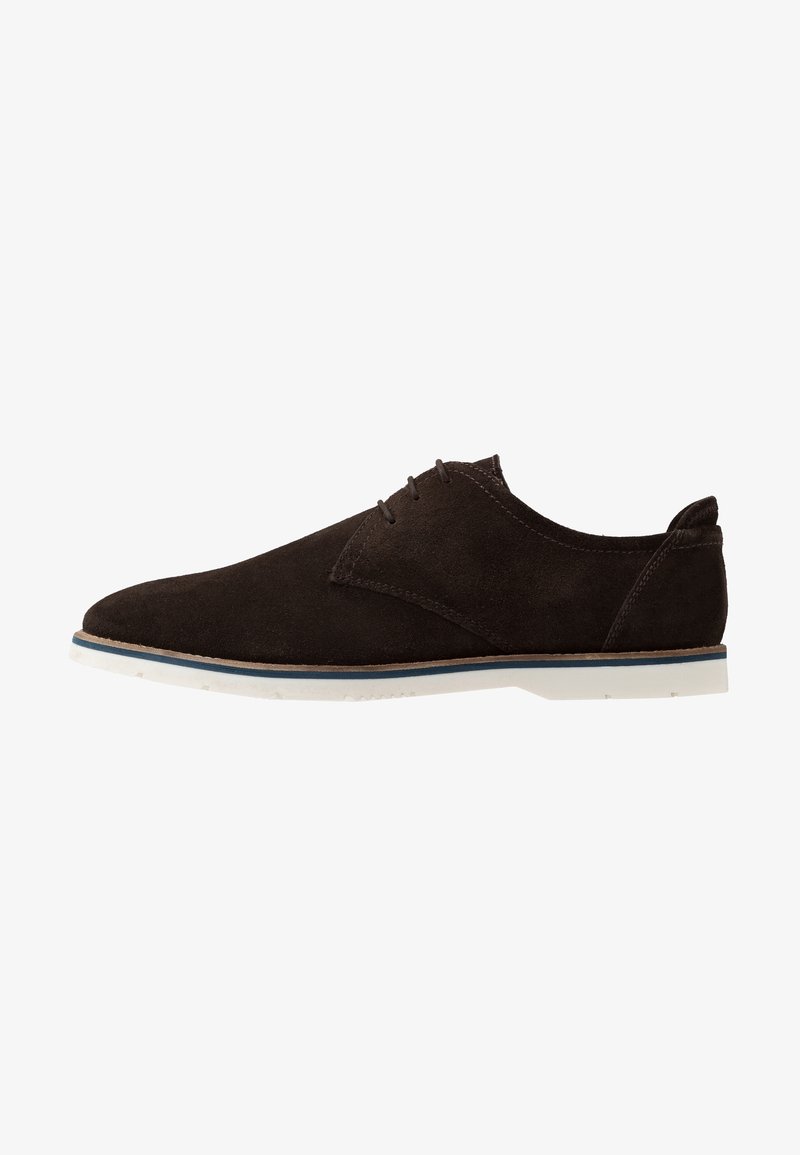 Chaussure à lacets pour homme en daim marron foncé avec semelle en caoutchouc blanche et bordure bleue, profil latéral sur fond blanc.