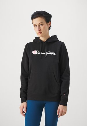 Sudadera negra con capucha y bolsillo tipo canguro en la parte frontal, con un logo "Champion" en glossy blanco y rosa. Cuenta con puños y dobladillo acanalados.