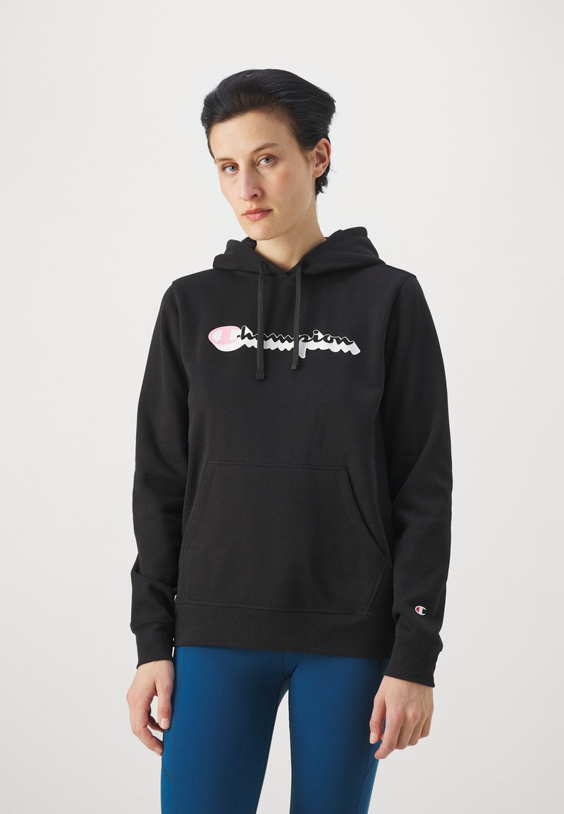 Čierna mikina s kapucňou, predným klokankovým vreckom a lesklým bielym a ružovým logom "Champion". Má ribbovaný lem a manžety.