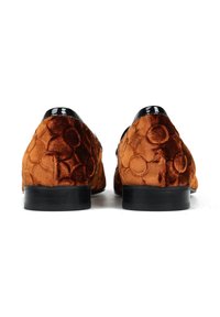 Para brązowych aksamitnych loafersów z tłoczonymi kwiatowymi wzorami i czarnym błyszczącym wykończeniem, pokazana z tyłu na białym tle.