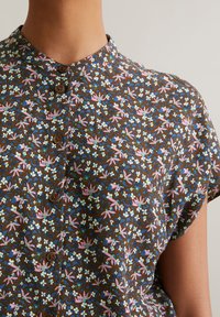 Bruine bloemenoverhemd met een spread collar, kleine knopen, korte mouwen en een print van roze, blauwe en witte bloemen op een gestructureerde stof.