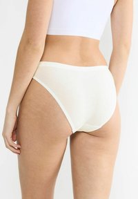 Weiße Baumwollunterwäsche mit glatter Textur und elastischem Bund, ausgestattet mit minimalen Nähten und einem klassischen Slip-Schnitt.