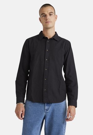 Black long-sleeve shirt with a button-up front and a collar, made of textured fabric. Features brown buttons along the placket.