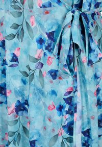 Tissu bleu clair avec un motif floral dans des tons de bleu, rose et gris, comportant un détail de nœud noué en haut à droite.