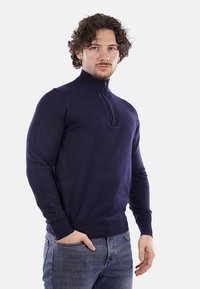 Maglione da uomo blu navy con colletto alto con zip, polsini e orlo ribattuti, realizzato in un tessuto lavorato a maglia liscio.