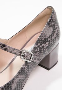 Šedá a černá ljango s hadím vzorem na blocích s podpatkem, špičatou špičkou a čtvercovou sponou přes nárt. Hladká podšívka.
