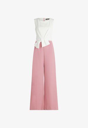 Ærmeløs hvid top i slå-om-stil kombineret med højtaljede, brede, lyserøde bukser, med en knudedetalje foran på toppen.