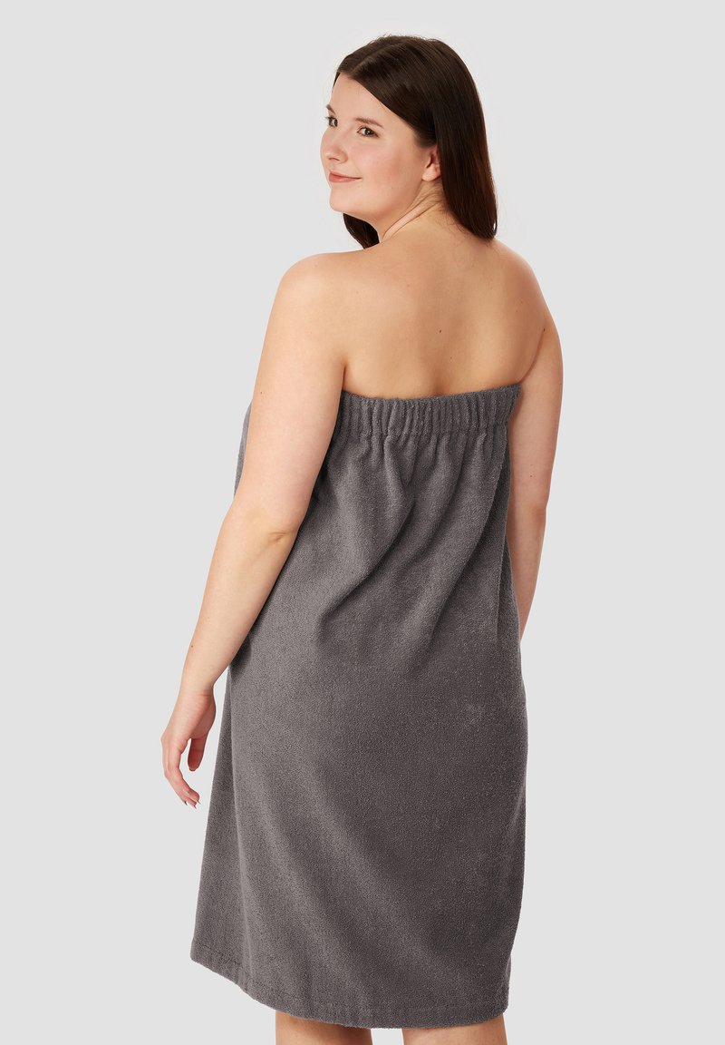 Serviette en éponge grise, design sans bretelles avec une taille élastique, longueur genoux, texture douce et couleur uniforme.