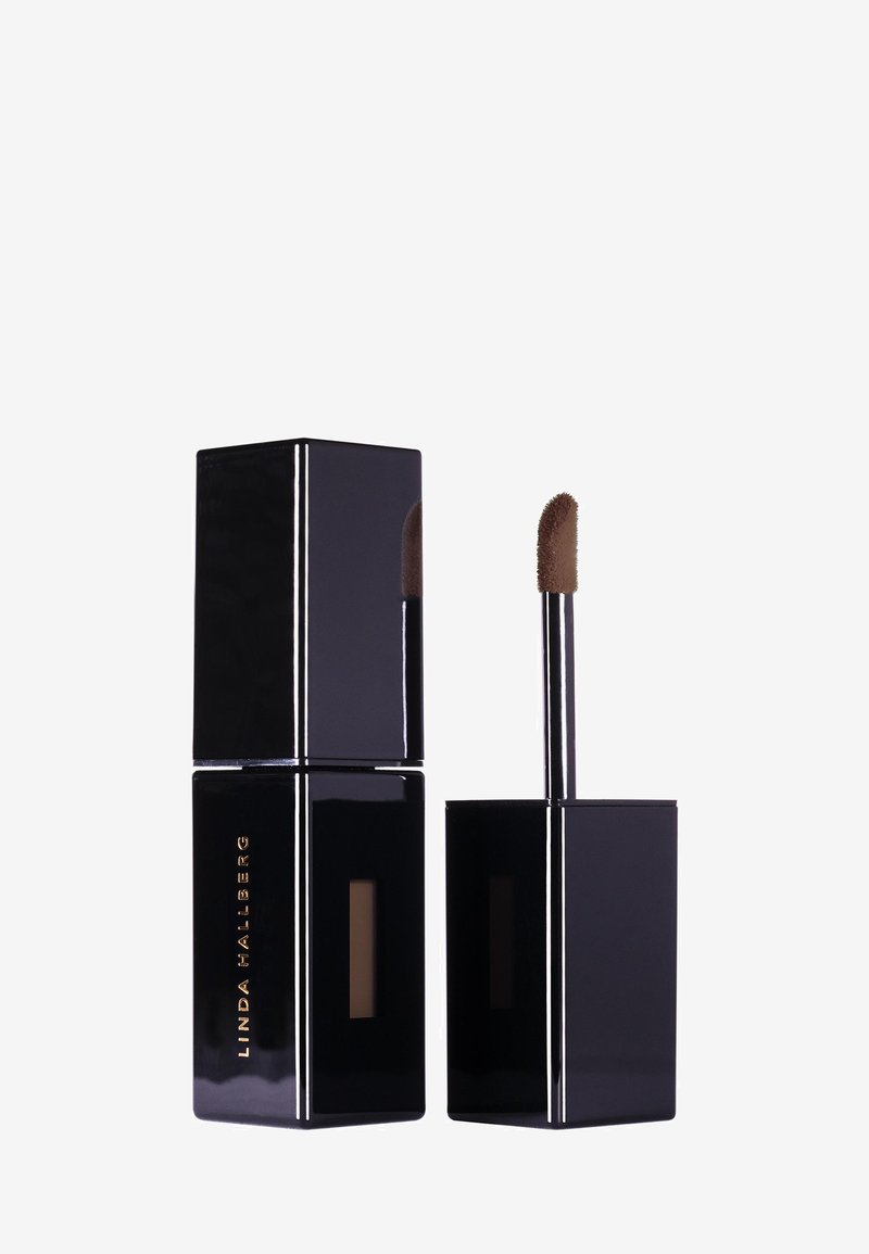 Flytende leppestiftprodukt i en svart firkantet beholder med en kort, skrå applikator. Har en glansfull finish og gulltekst.