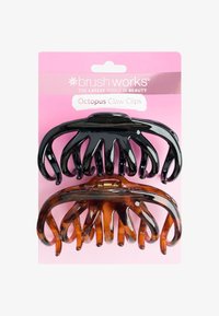 Due grandi clip per capelli a forma di polpo, una nera e una tartarugata, su una scheda di confezionamento Brush Works rosa.