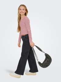 Prugasta crvena i bijela majica dugih rukava, crne široke traperice i bijeletenisice. Nosimo crnu torbu od pletiva s zakrivljenim oblikom.