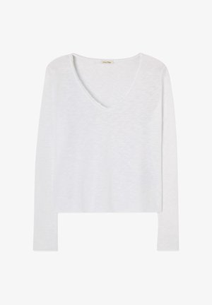Valge pika varrukaga V-kaelusega puuvillane topp, millel on kergelt tekstureeritud kangas ja viimistlemata äärisega kaelus.