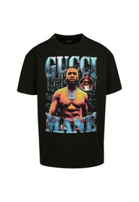 Black cotton T-shirt featuring a colorful graphic of a muscular figure and the text "GUCCI MANE" in large icy blue letters.