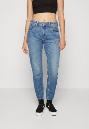 Classic kék farmer, tapered láb, öt zsebes dizájn, közép magas derék, denim anyagból készült, gombos és cipzáras zárással ellátva.