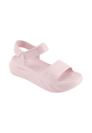 Lichtroze plateau sandaal met dikke zool, open teen en verstelbare band rond de enkel, gemaakt van zacht materiaal.