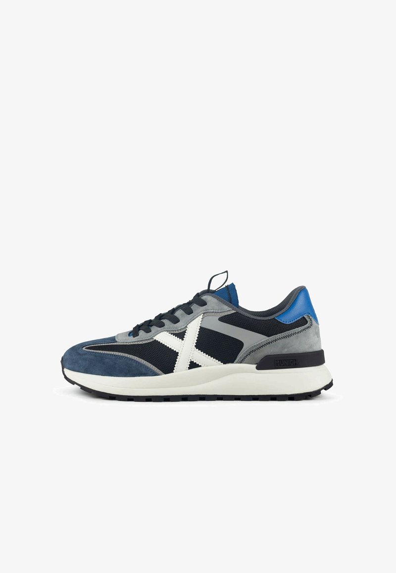 Chaussures de sport bleu marine et grises en suède et mesh, avec un logo X blanc, une semelle noire et des accents bleus au talon.