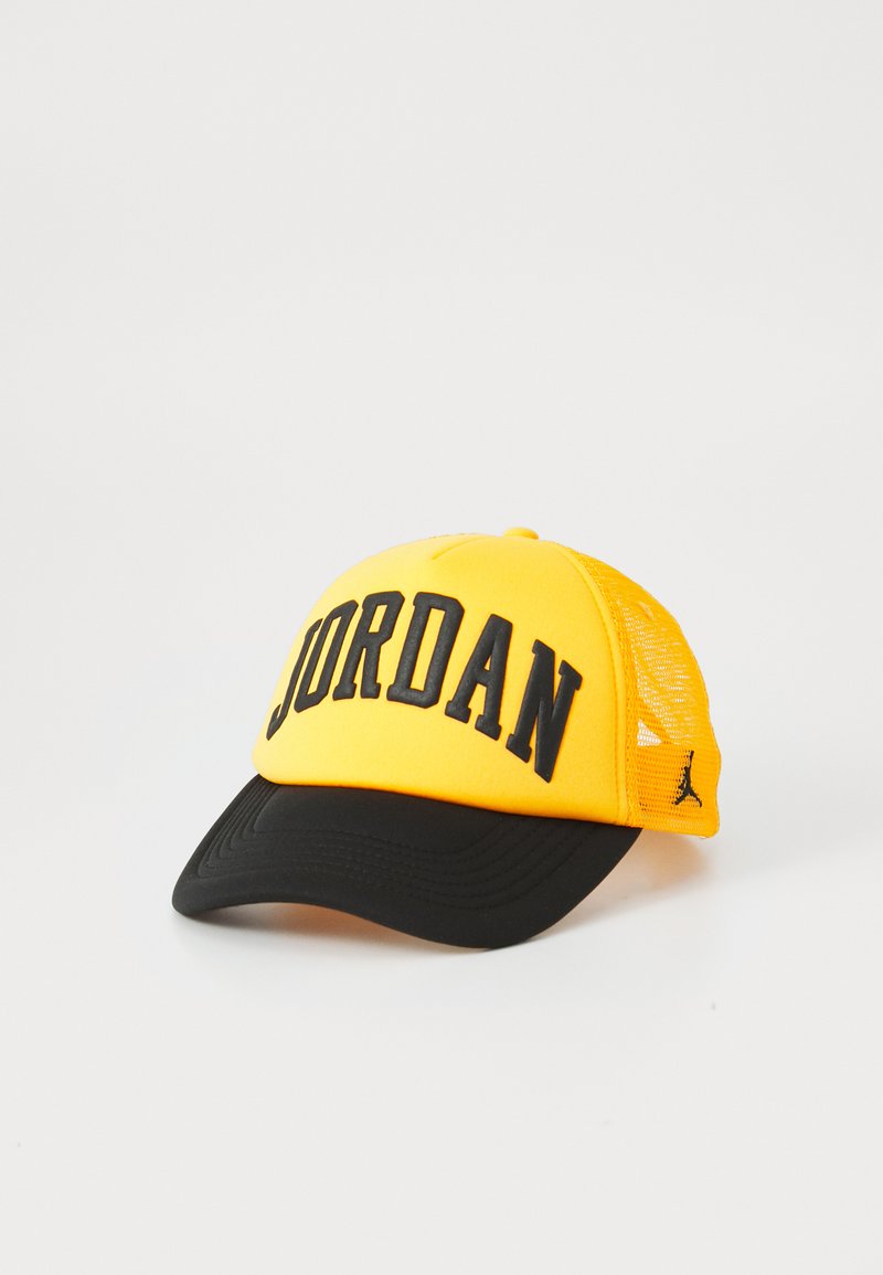Rumena bejzbol kapa z črnim napisom "JORDAN", s črnim vizirjem in mrežastim zaledjem, ter z majhnim logotipom na strani.