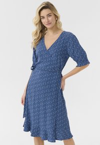 Modra obleka z zavihkom s kratkimi napihnjenimi rokavi, cvetličnim vzorcem, V-izrezom in razširjenim robom. Narejena iz lahkega materiala za udobje.