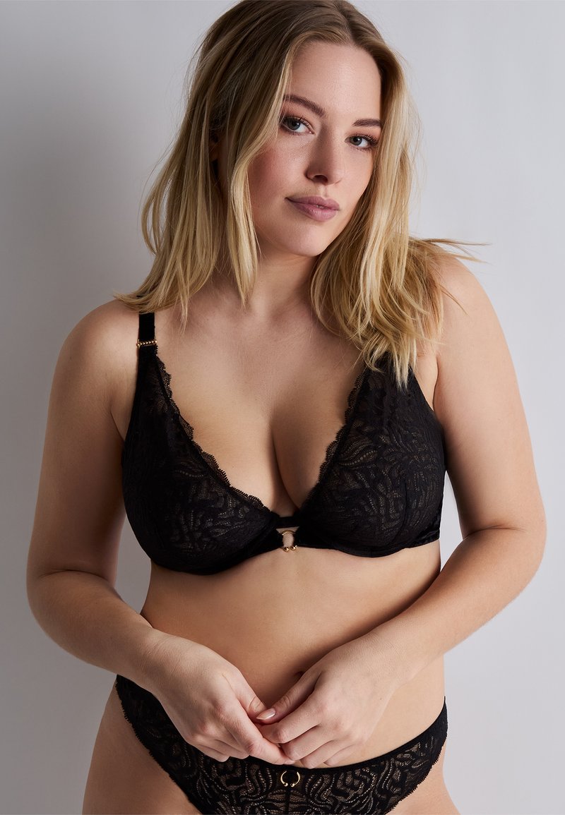 Soutien-gorge en dentelle noire et culotte assortie avec un motif floral, des bords festonnés, et des accents dorés au centre et sur les bretelles.