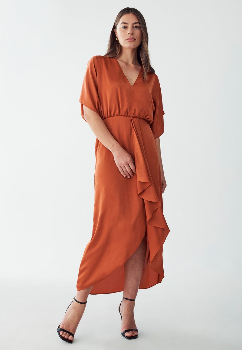 Rostfarbene Kleid mit V-Ausschnitt, kurzen Ärmeln und taillierter Taille. Mit seitlichem Rüschendetail und einem Schlitzen bis zum Oberschenkel, aus glattem Stoff.