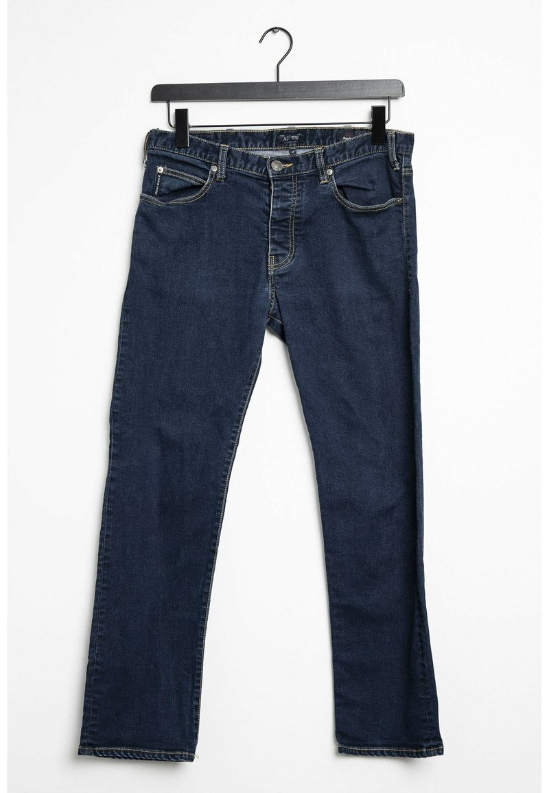 Jeans en denim bleu foncé avec une coupe droite, cinq poches, des détails en surpiqûre et une fermeture à bouton. Accrochés à un crochet noir.