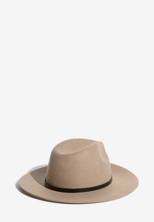 Light brown wide-brimmed fedora hat with a black band around the base, set against a plain white background.
