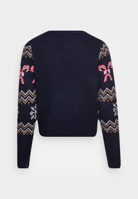 Pull marin avec une coupe ajustée, présentant des motifs de sucre d'orge et de flocons de neige sur les manches à motifs. Détails de col et ourlet côtelés.
