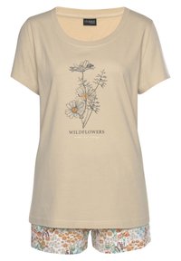 Beige katoenen t-shirt met een bloemenmotief, featuring wilde bloemen en de tekst "WILDFLOWERS maken me blij." Gecombineerd met kleurrijke bloemen shorts.