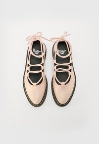 Sapatos de couro rosa com atacadores pretos, apresentando um bico redondo, sola de borracha grossa e costura amarela ao longo da borda.