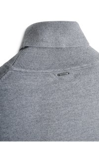 Grijze trui met een geribbelde hoge kraag, met een gladde textuur en een klein metallic label op de achterkant van de halslijn.