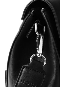 Černá kožená kabelka s křivkovým designem, vybavená stříbrným kovovým zapínáním a texturovaným upevněním řemínku. Je viditelné prošívání.