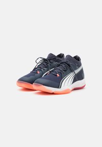 Scarpe sportive marine con tomaia in rete, strisce bianche e dettagli arancioni; suola arrotondata con grip testurizzato per una buona aderenza.