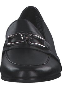 Mocassins en cuir noir avec une semelle plate, un design épuré et une accent en boucle argentée à l'avant. Texture lisse, forme arrondie.