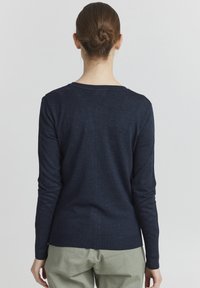 Pull à manches longues bleu marine en tricot doux, avec un col rond et une silhouette ajustée. Design simple et sans couture.